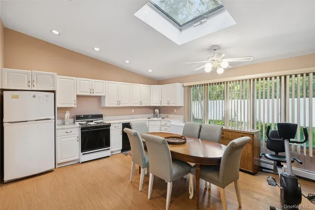 a view of kitchen with stainless steel appliances granite countertop a stove a refrigerator a table and chairs