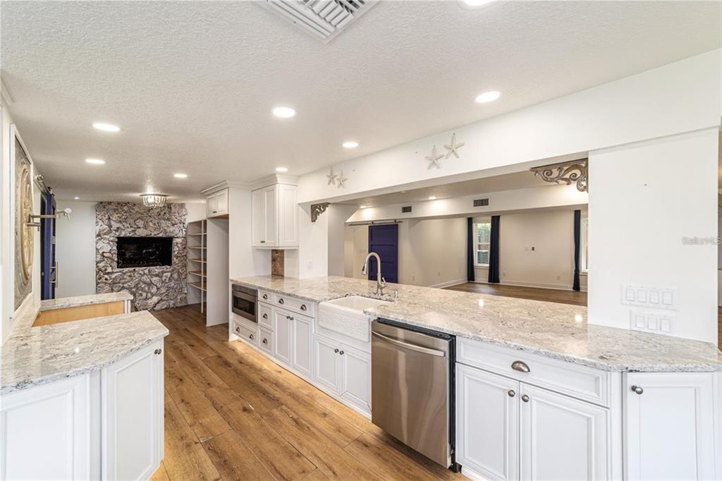 10399 Northeast 218th Lane Road Fort McCoy, FL 32134 - Photo 18 of 68 a large kitchen with stainless steel appliances kitchen island granite countertop a large counter top and stove top oven