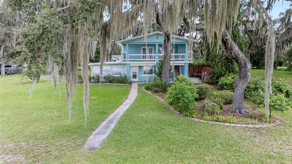 10399 Northeast 218th Lane Road Fort McCoy, FL 32134 - Photo 2 of 68 a view of a house with a big yard plants and large trees
