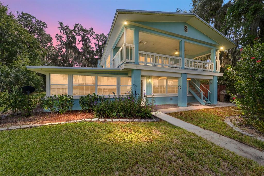 10399 Northeast 218th Lane Road Fort McCoy, FL 32134 - Photo 5 of 68 a front view of a house with garden