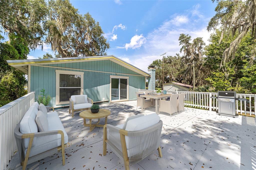 10399 Northeast 218th Lane Road Fort McCoy, FL 32134 - Photo 52 of 68 a view of a patio with a dining table and chairs with wooden floor