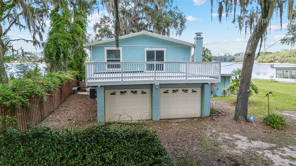 10399 Northeast 218th Lane Road Fort McCoy, FL 32134 - Photo 60 of 68 a view of backyard of house with wooden fence and large trees