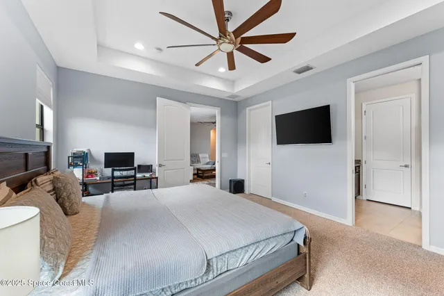 a bedroom with a bed flat screen tv and couches