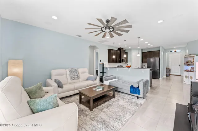 a living room with furniture and a view of kitchen