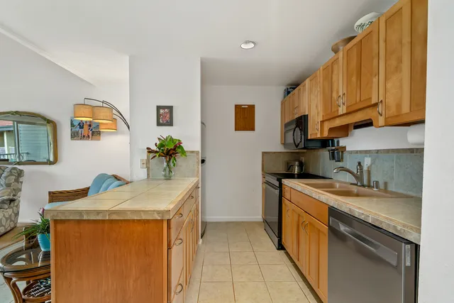 a kitchen with stainless steel appliances granite countertop a sink stove and cabinets