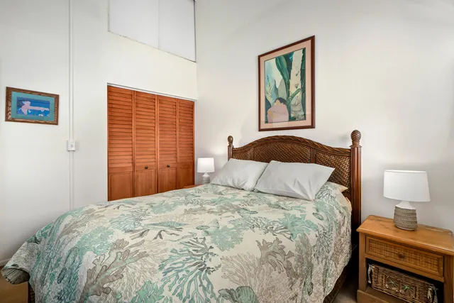 a bedroom with a bed and a lamp on dresser