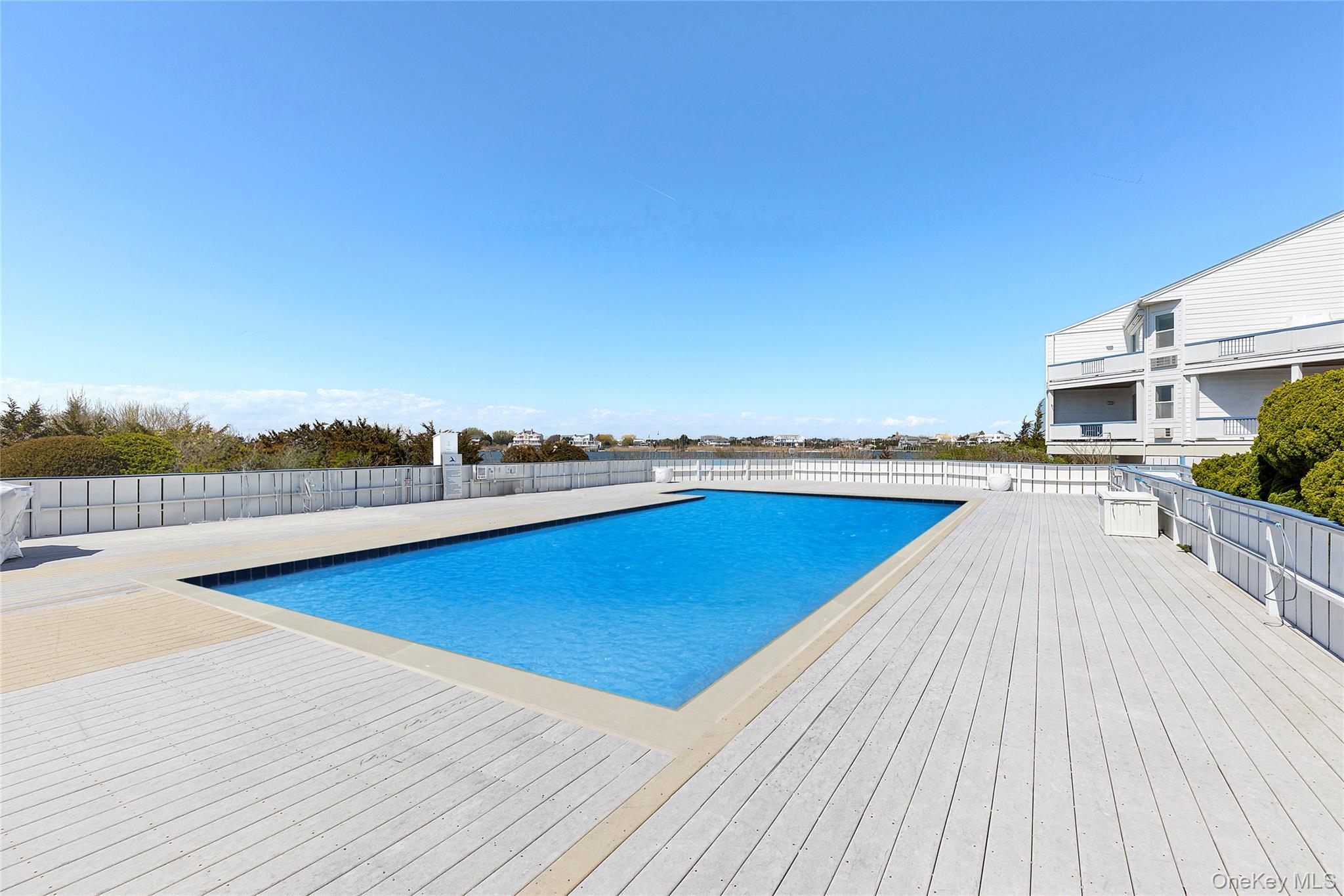 250 Dune Road, Unit 119 Westhampton Beach, NY 11978 - Photo 2 of 8 a view of a swimming pool and lounge chair