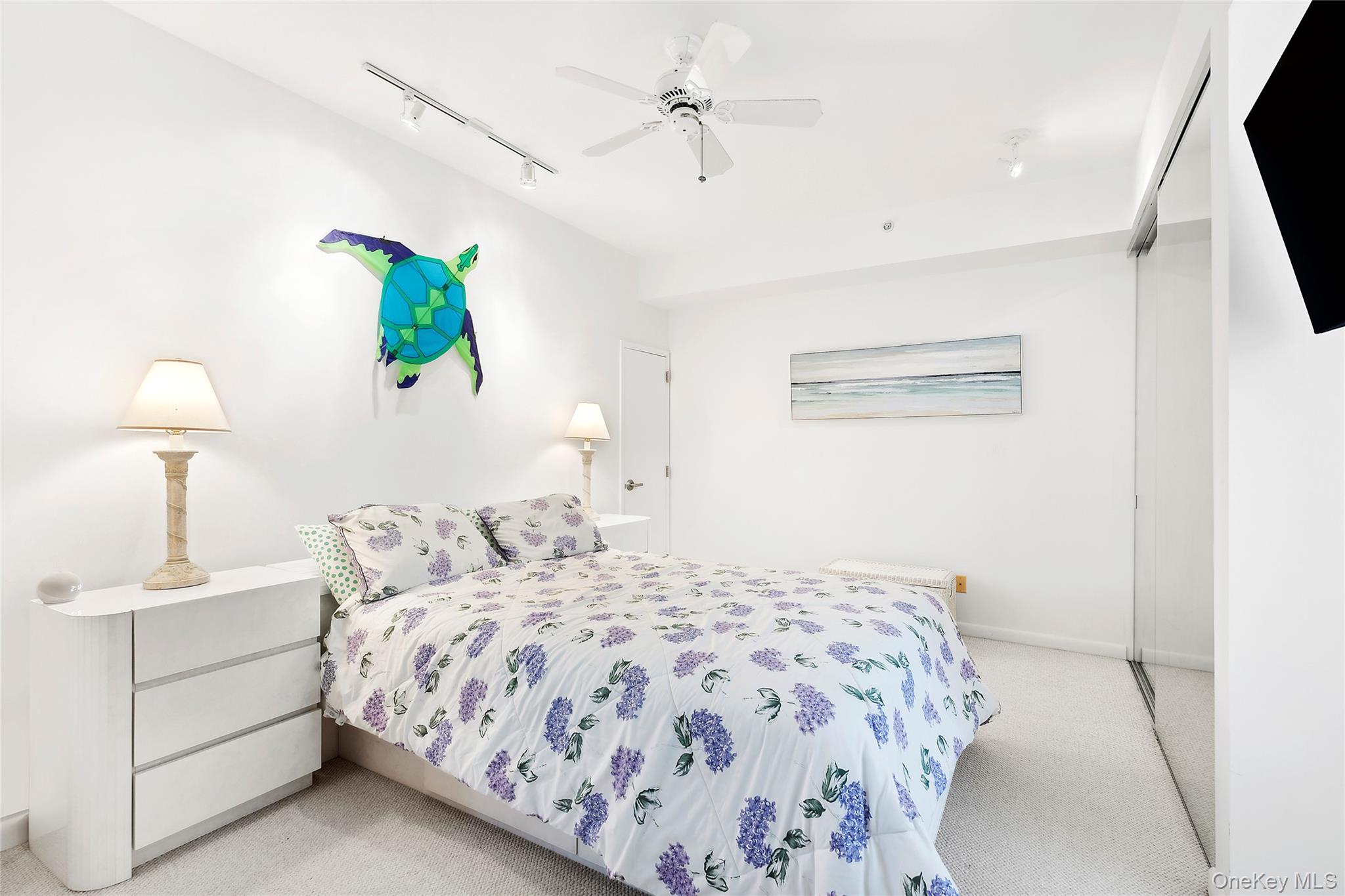 250 Dune Road, Unit 119 Westhampton Beach, NY 11978 - Photo 7 of 8 a bedroom with a bed and a chandelier