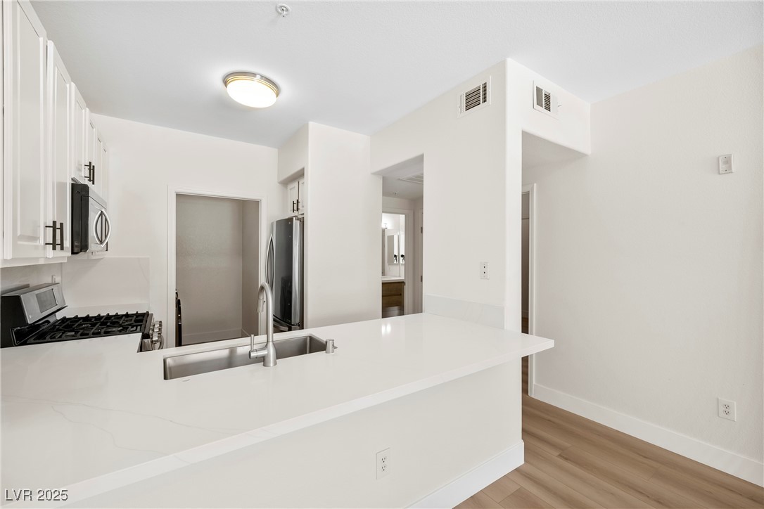 7139 South Durango Drive, Unit 203 Las Vegas, NV 89113 - Photo 11 of 25 Kitchen with white cabinetry,Brand new countertop, Bend new sink and faucet