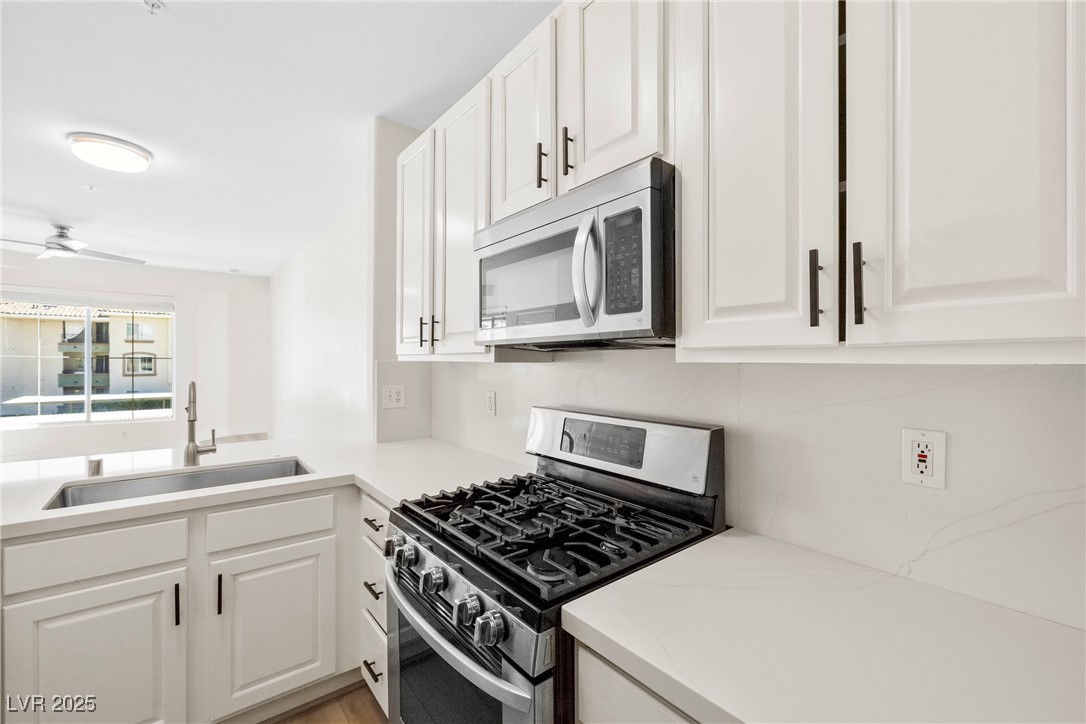 7139 South Durango Drive, Unit 203 Las Vegas, NV 89113 - Photo 13 of 25 Kitchen featuring appliances with stainless steel finishes, white cabinets, brand new sink