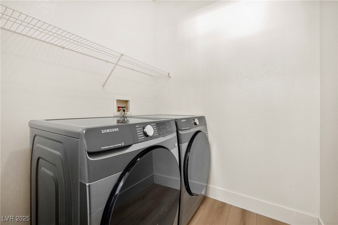 7139 South Durango Drive, Unit 203 Las Vegas, NV 89113 - Photo 14 of 25 Laundry area featuring brand new washer and clothes dryer and wood finished floors