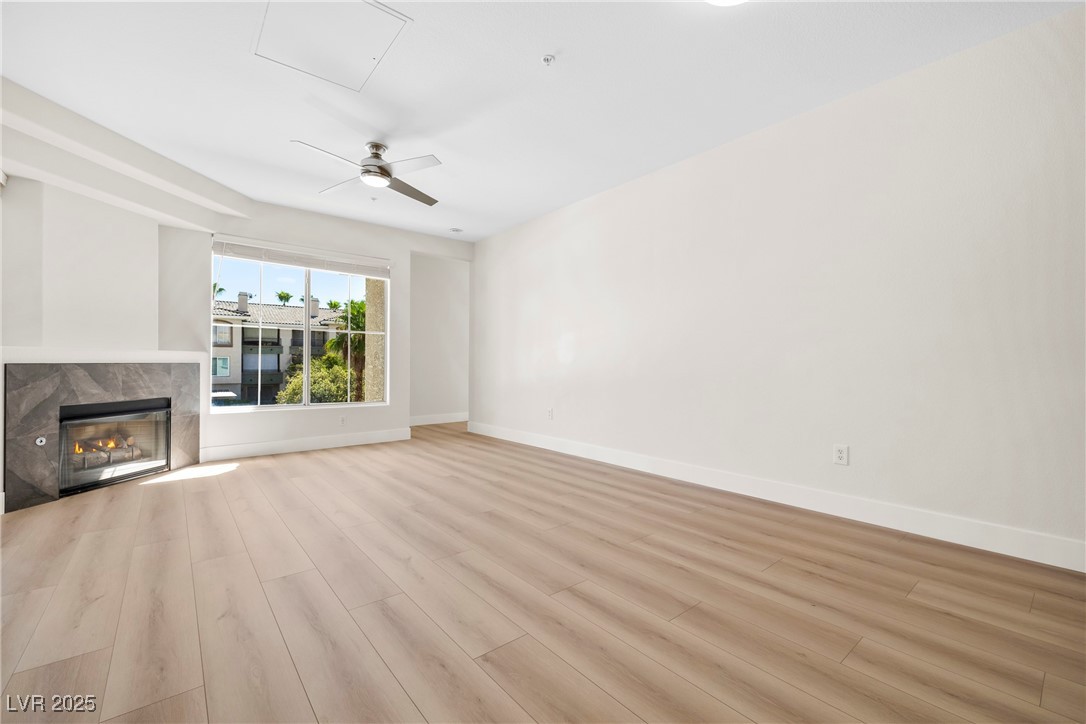 7139 South Durango Drive, Unit 203 Las Vegas, NV 89113 - Photo 8 of 25 iving room featuring a fireplace, light wood-style floors, and ceiling fan