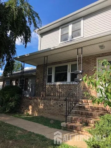 a front view of a house with a tree