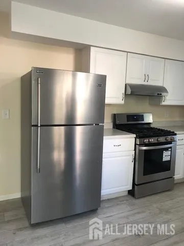 a kitchen with stainless steel appliances granite countertop a refrigerator and a stove
