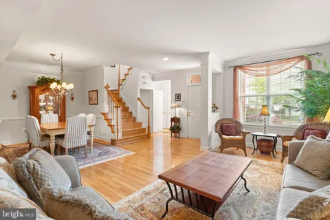a living room with furniture a chandelier and a dining table