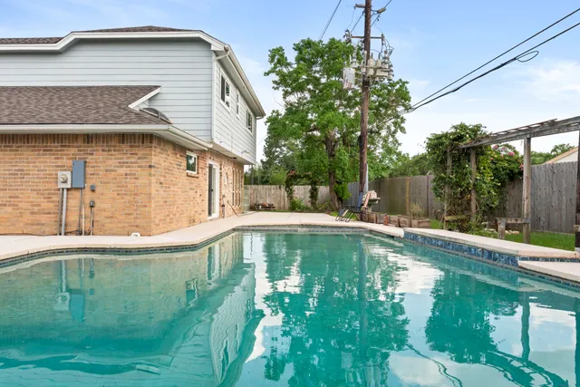 a house view with swimming pool in front of it