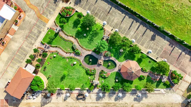 an aerial view of residential houses with outdoor space and trees