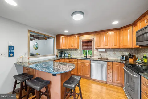 a kitchen with stainless steel appliances granite countertop sink stove top oven and cabinets