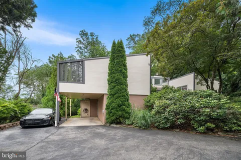 a backyard of a house with a garden and outdoor seating
