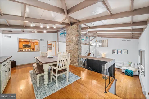 a dining room with furniture a chandelier and wooden floor