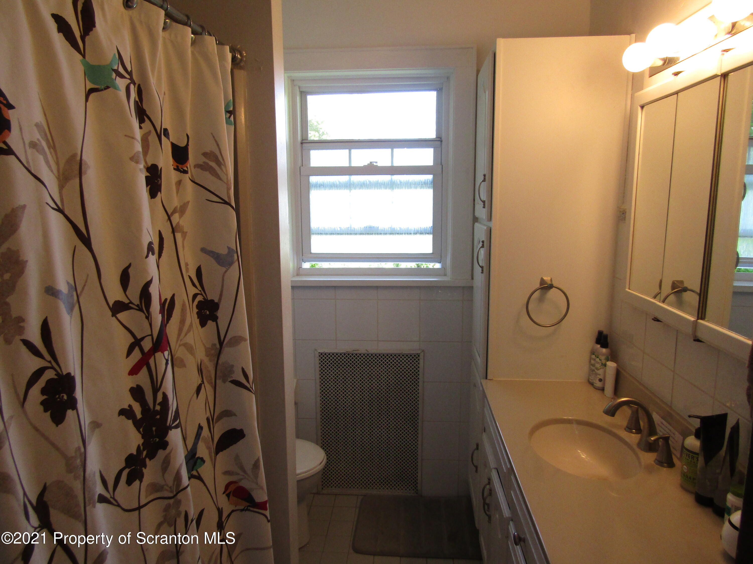 1314 State Rte 435 Moscow, PA 18444 - Photo 23 of 27 a bathroom with a sink and mirror with bathtub