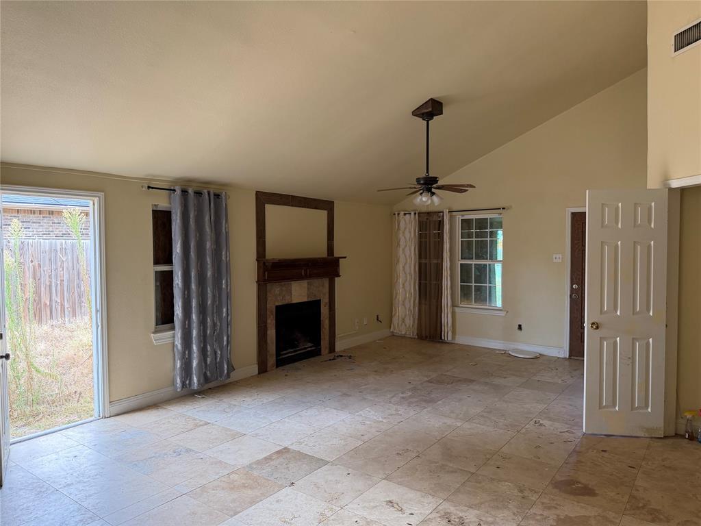 10823 Addie Road Dallas, TX 75217 - Photo 6 of 20 Vaulted ceiling, ceiling fan, tile flooring, fireplace with tile surround, and rear yard access