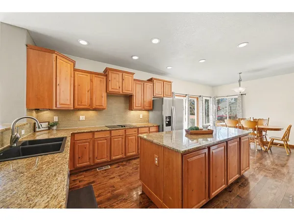 a kitchen with stainless steel appliances granite countertop a sink stove and cabinets