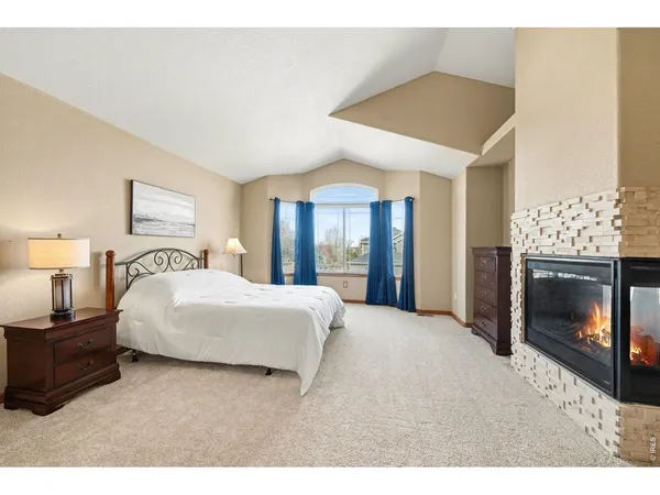 a spacious bedroom with a bed and a fireplace