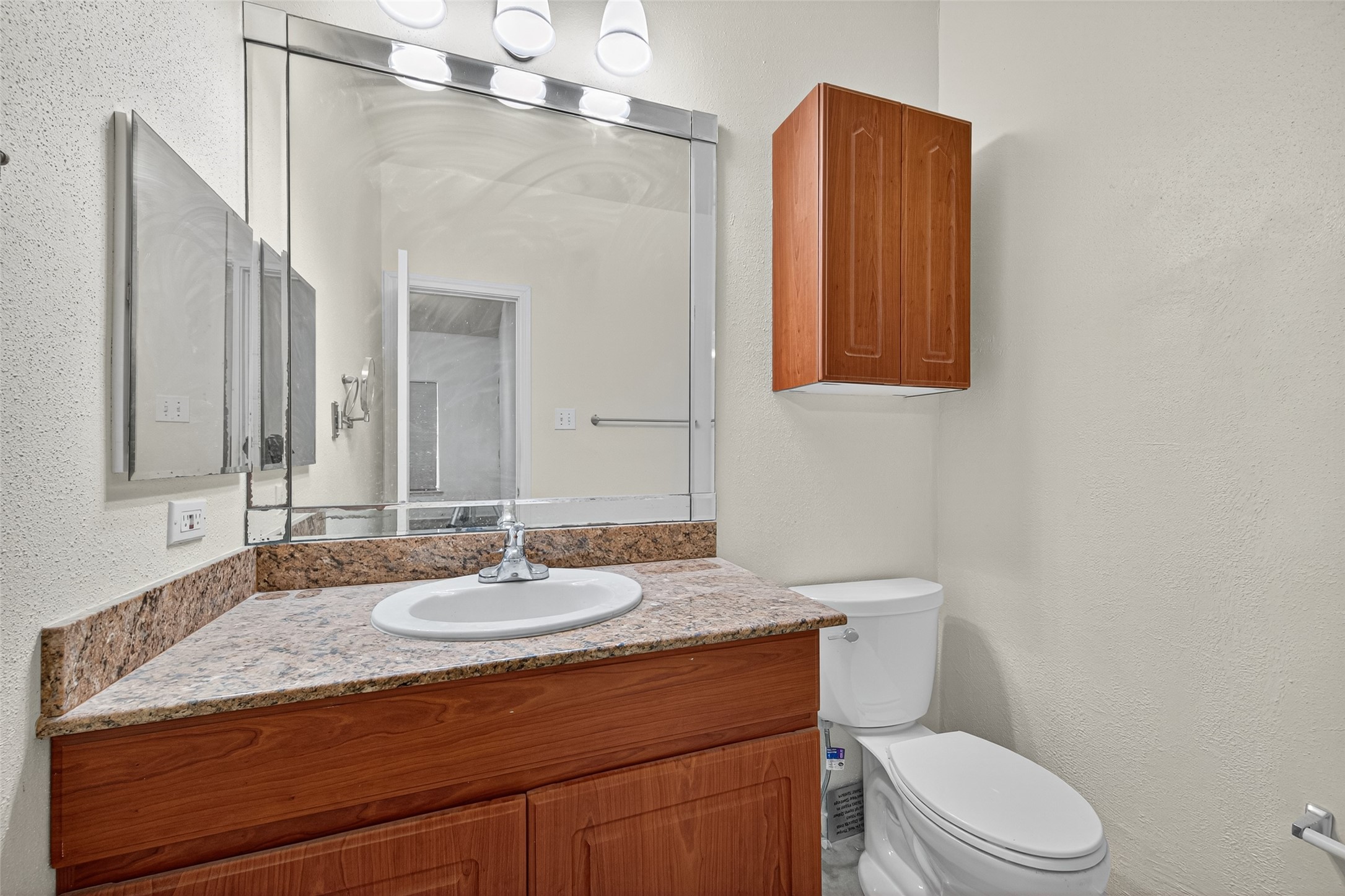 4041 Drake Street, Unit 203 Houston, TX 77005 - Photo 16 of 26 a bathroom with a granite countertop sink mirror vanity and toilet