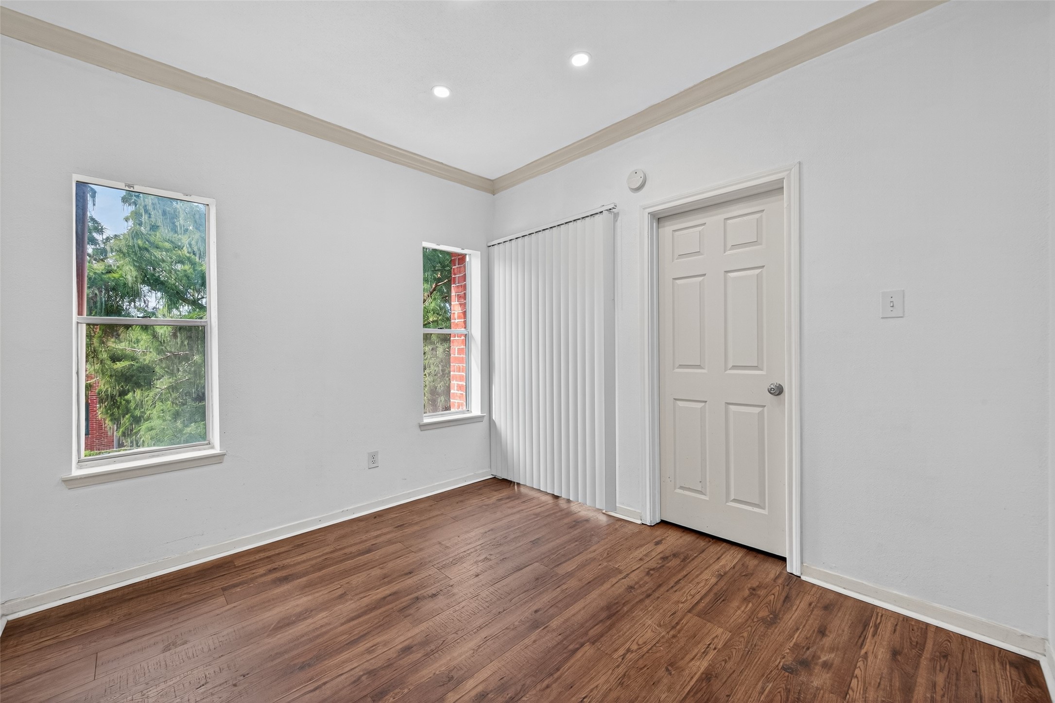 4041 Drake Street, Unit 203 Houston, TX 77005 - Photo 4 of 26 a view of an empty room with wooden floor and a window