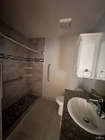 a bathroom with a sink toilet a mirror and shower