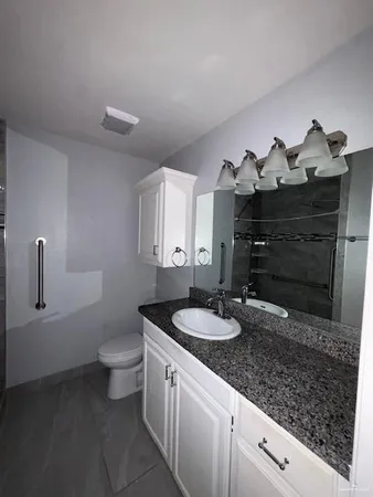 a bathroom with a granite countertop sink and a mirror