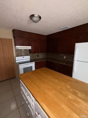 a kitchen with stainless steel appliances a refrigerator and a stove top oven
