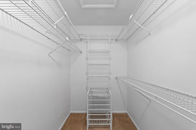 a view of walk in closet with empty racks