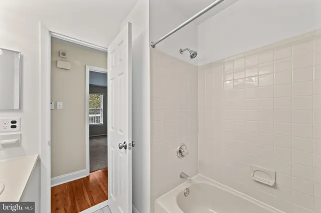 a bathroom with a tub shower vanity and a sink