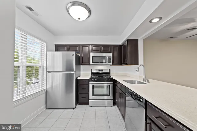 a kitchen with stainless steel appliances a refrigerator sink and microwave