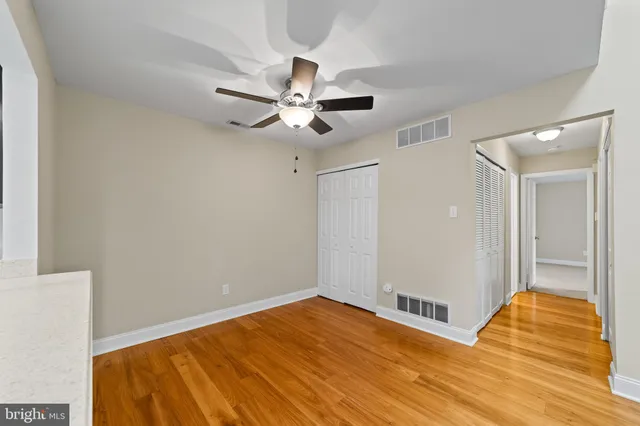 a view of room with wooden floor and ceiling fan