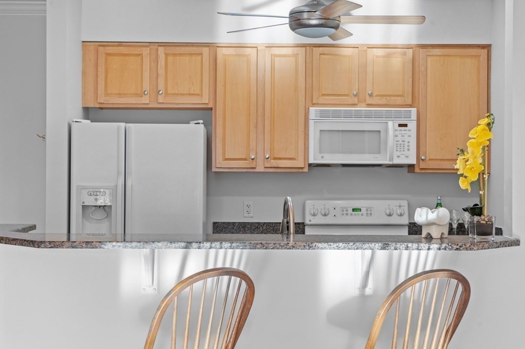 190 Chickering Road, Unit 208D North Andover, MA 01845 - Photo 6 of 42 a kitchen with stainless steel appliances granite countertop a stove a sink and a microwave