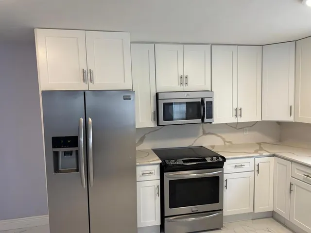 a view of a kitchen cabinets and a refrigerator