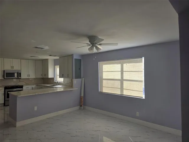 a kitchen with granite countertop a stove and a white cabinet