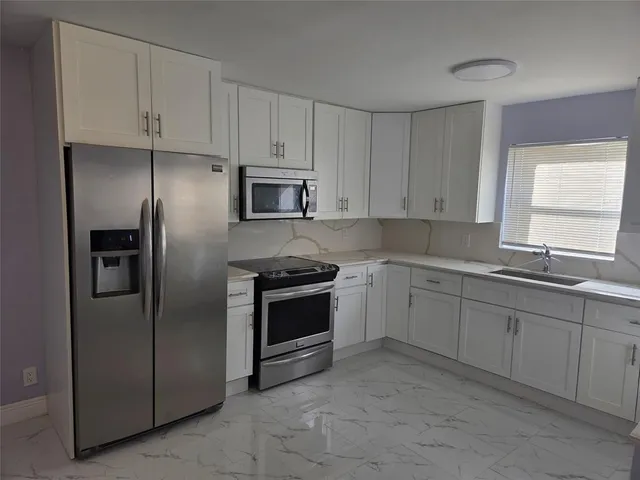 a kitchen with a sink stove and cabinets