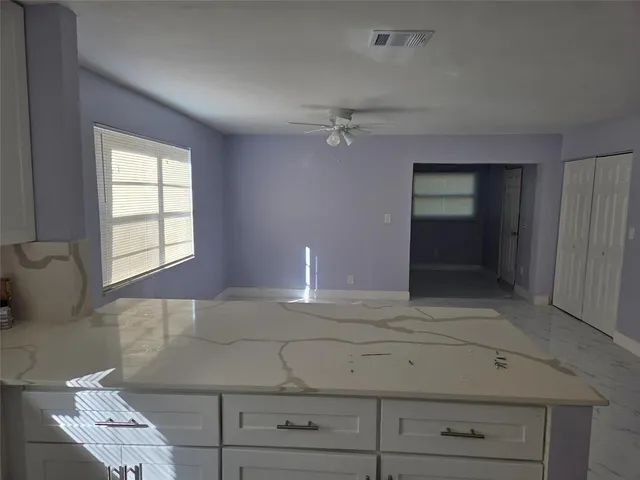 an empty room with a fan and a fan