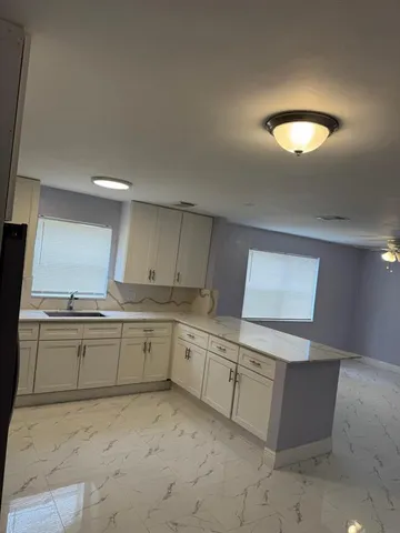 a kitchen with stainless steel appliances a refrigerator sink and microwave