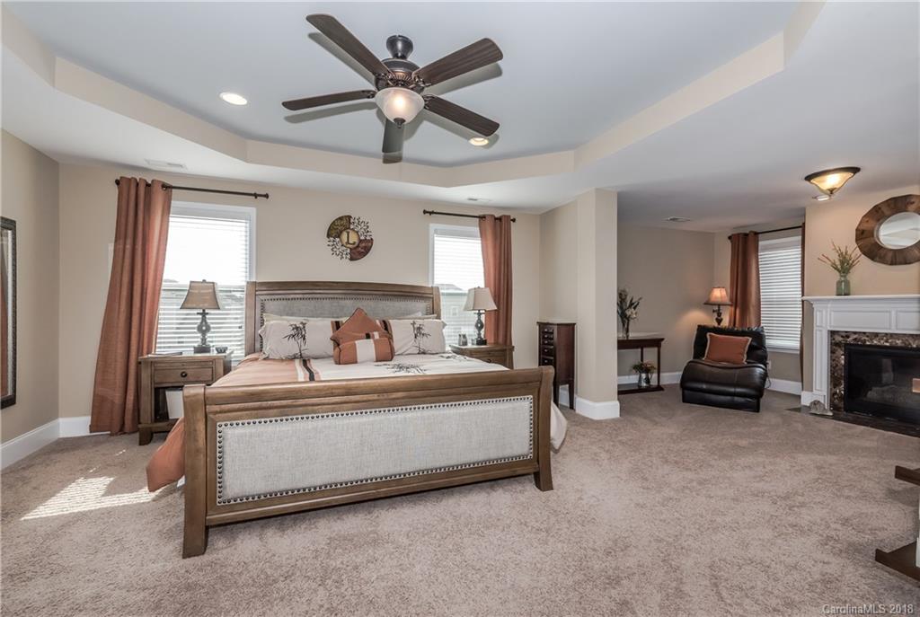 79180 Ridgehaven Road Lancaster, SC 29720 - Photo 12 of 24 a spacious bedroom with a bed a fireplace and a large mirror