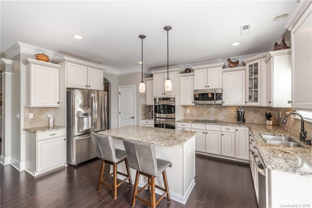79180 Ridgehaven Road Lancaster, SC 29720 - Photo 6 of 24 a kitchen with stainless steel appliances kitchen island granite countertop a refrigerator a sink dishwasher a stove and white cabinets with wooden floor