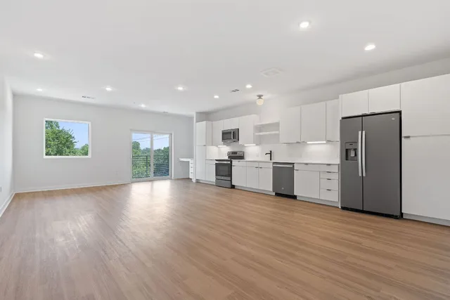 a view of a kitchen with stainless steel appliances refrigerator microwave and stove
