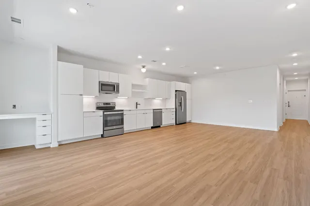 a kitchen with stainless steel appliances a refrigerator and a stove top oven