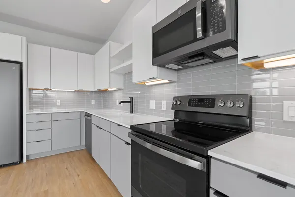 a kitchen with stainless steel appliances a stove a microwave and cabinets