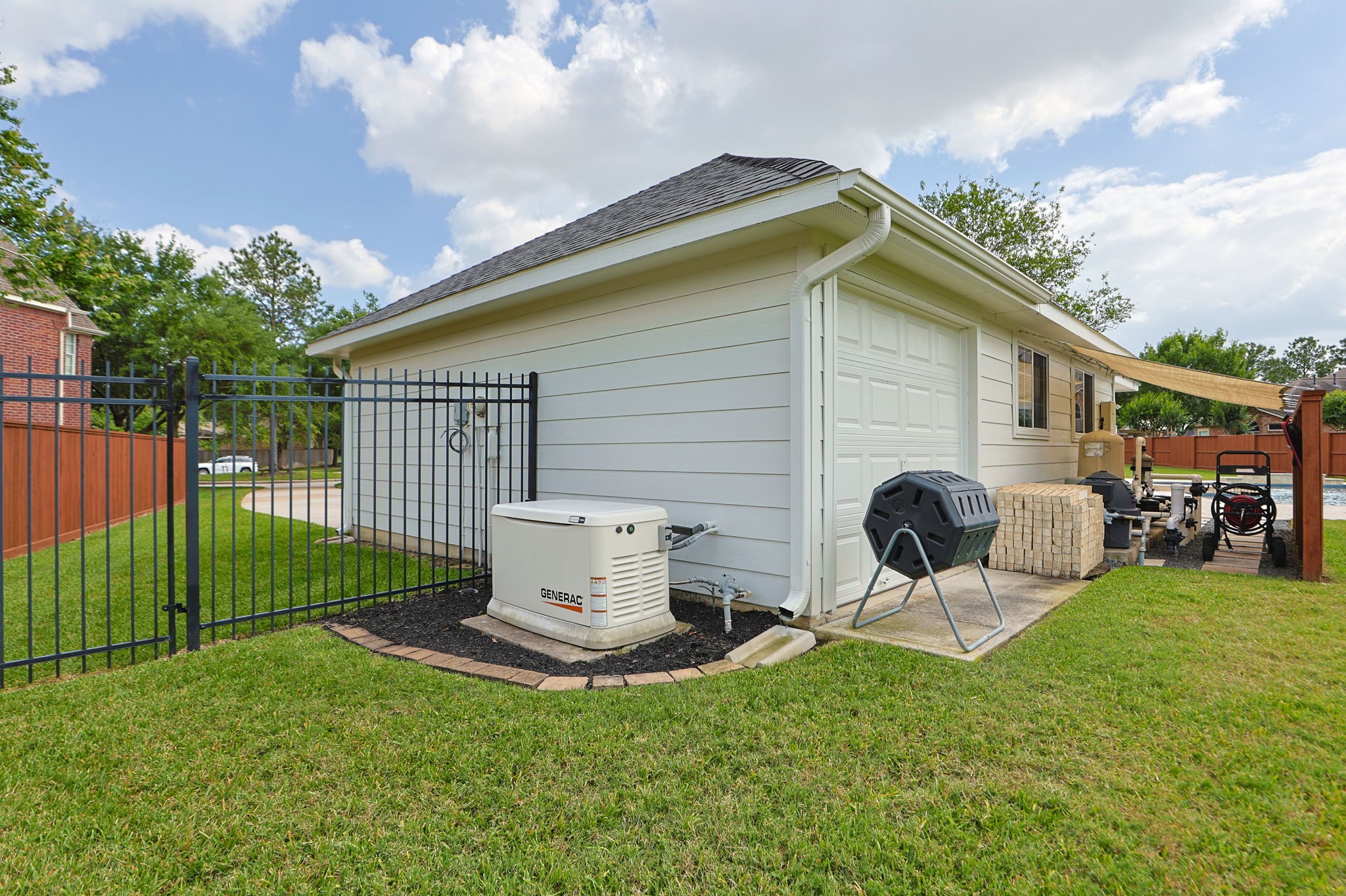 10203 Noble Pointe Court Spring, TX 77379 - Photo 33 of 50 2022 24 KW Generac generator. Garage has secondary overhead door in the back. Shade sail to protect pool equipment.