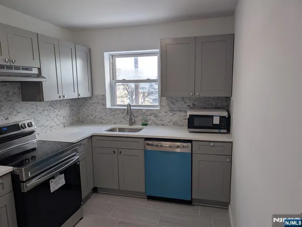 a metallic refrigerator freezer sitting inside of a kitchen